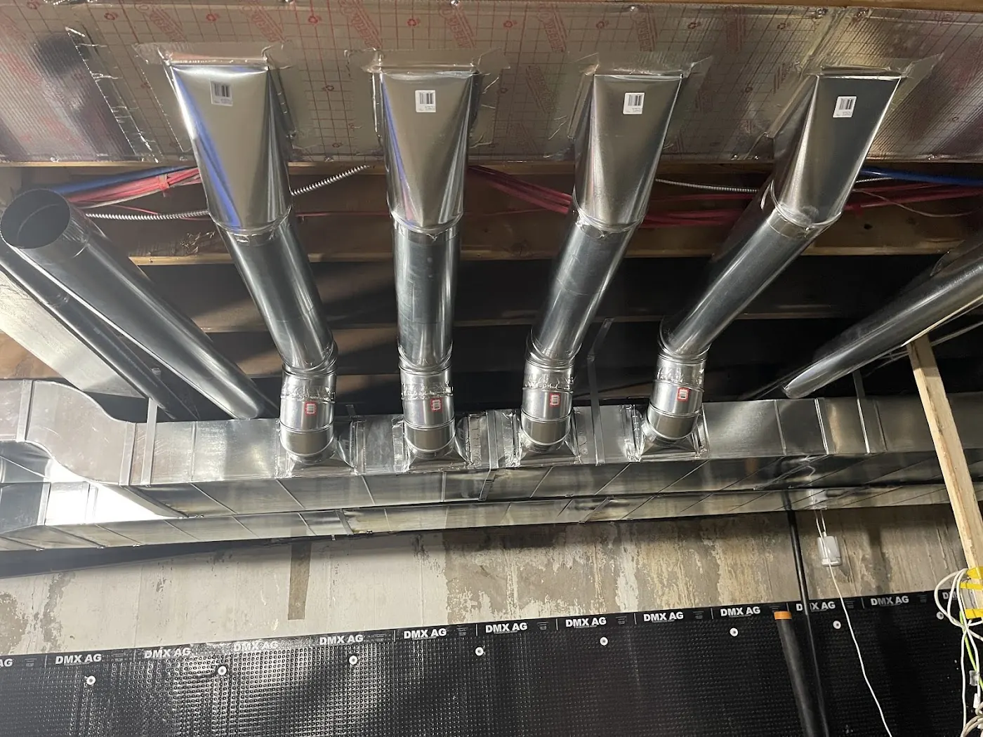 Custom galvanized HVAC duct branches installed under floor joists